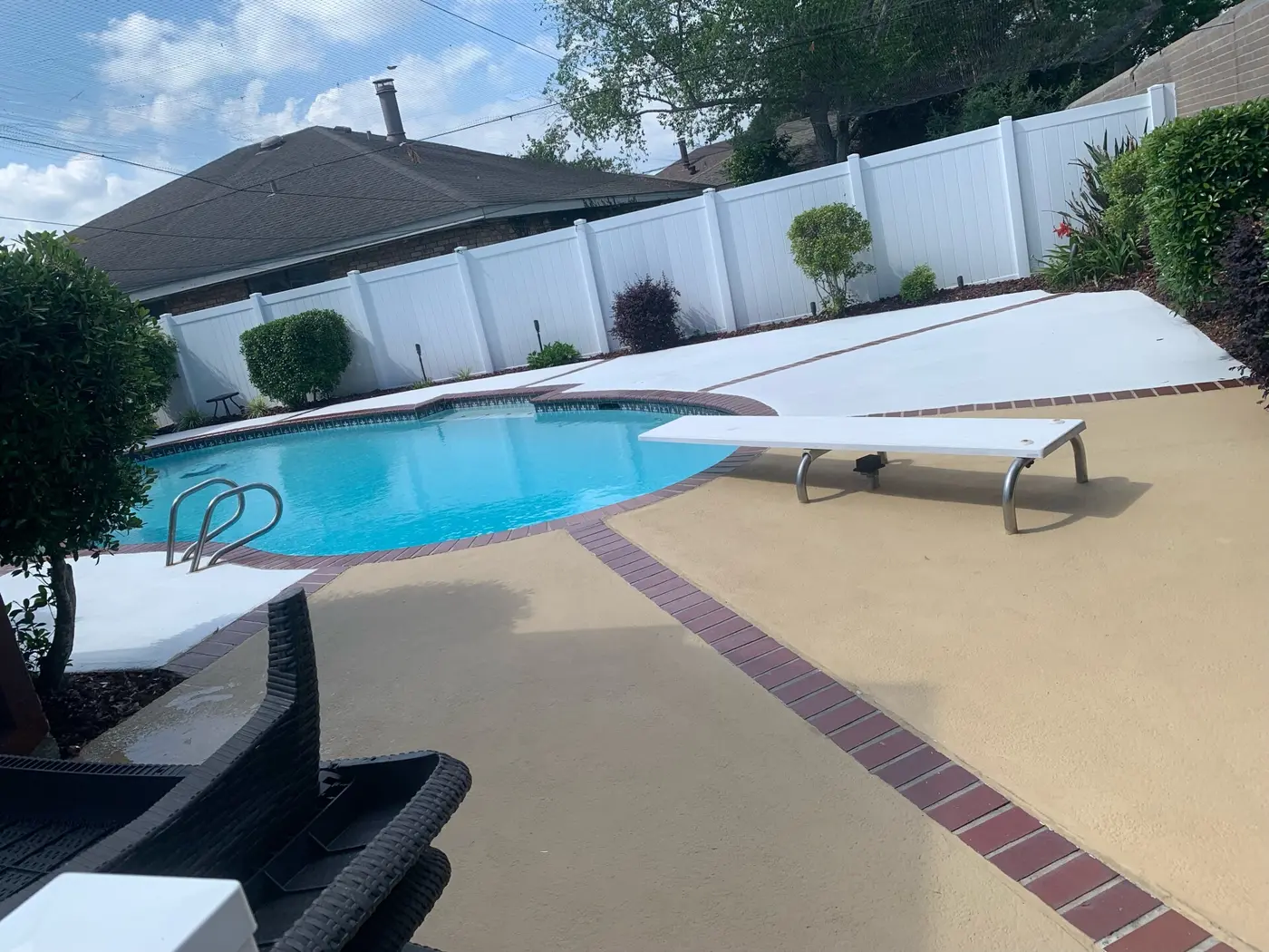 Sunny kidney-shaped pool with a diving board